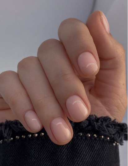 Short, rounded nails with a glossy milky blush-pink neutral finish, offering a clean and understated look for nail designs for short nail beds.