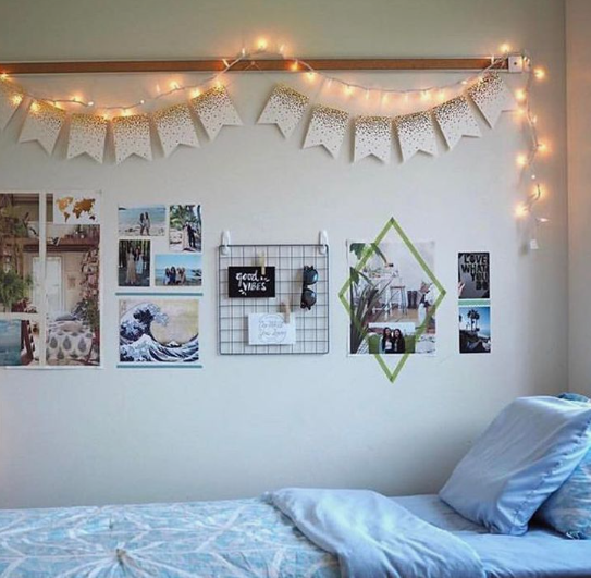 10 DIY Dorm Room Decor Ideas on a Budget That Look Amazing DIY dorm room decor ideas on a budget featuring warm fairy lights, a glitter pennant banner, a wire photo grid, and a collage wall above a light blue bed.