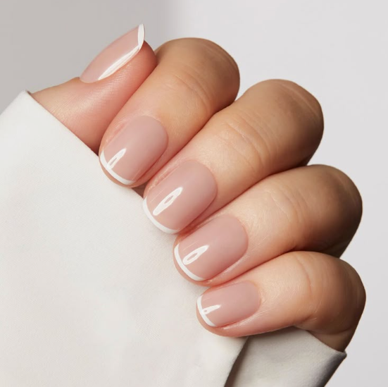 Classic French manicure with a sheer nude base and thin white tips, exemplifying timeless office-friendly nail designs.