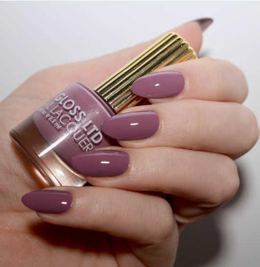 Glossy mauve-pink oval nails holding a matching nail lacquer bottle, creating a polished option for office-friendly nail designs.