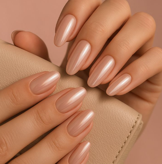 Long oval glossy pearlescent nude nails resting against a matching leather accessory, bringing an elegant finish to office-friendly nail designs.