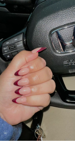 Almond-shaped neutral-pink nails with deep burgundy side-swept French tips, offering a chic and polished option for office-friendly nail designs.