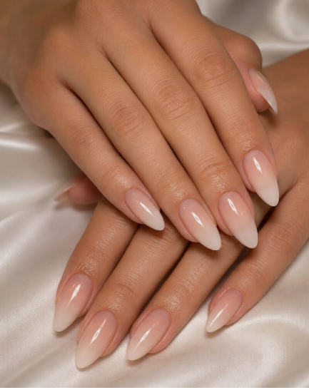 Almond-shaped nails with a soft nude-to-white ombre gradient finish, offering a timeless and classic look for office-friendly nail designs.