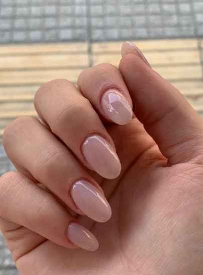 Short oval milky sheer pink nails with a clean, high-gloss finish, delivering a timeless and understated look for office-friendly nail designs.