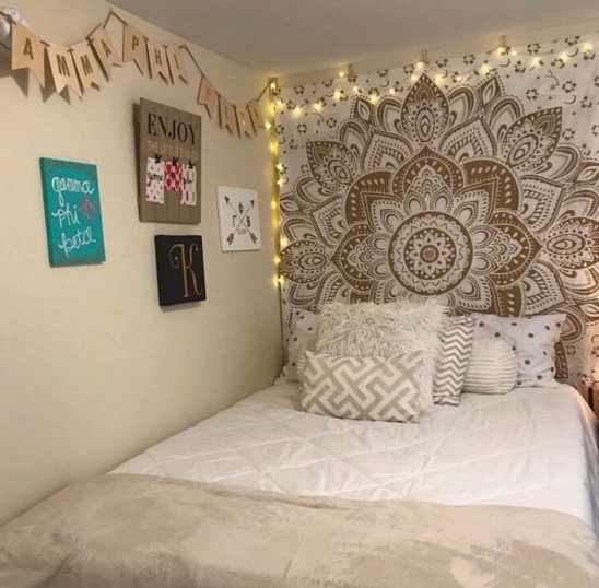10 DIY Dorm Room Decor Ideas on a Budget That Look Amazing DIY dorm room decor ideas on a budget featuring a white bed with patterned throw pillows beneath a large brown and white mandala tapestry adorned with string lights, accompanied by a wall gallery of framed art, a canvas print, and a letter banner.