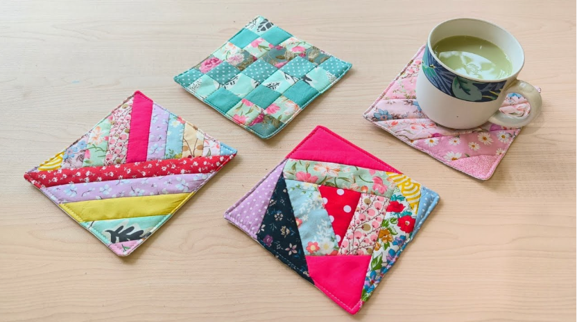 20 No-Sew DIY Crafts for Adults Four colorful patchwork fabric coasters featuring woven and striped geometric patterns on a wooden surface, with a mug resting on one, showcasing creative no-sew DIY crafts for adults.