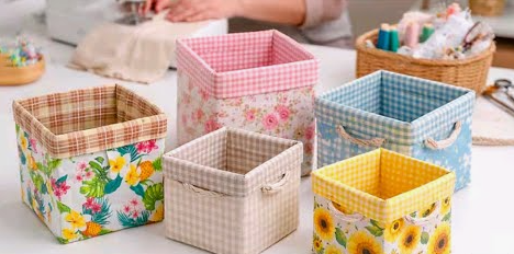20 No-Sew DIY Crafts for Adults Arrangement of five square fabric-covered storage baskets featuring floral, tropical, and gingham patterns with rope handles, showcasing creative no-sew DIY crafts for adults.