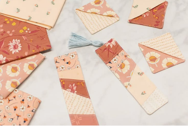 20 No-Sew DIY Crafts for Adults Collection of handmade fabric bookmarks and corner bookmarks featuring floral patterns in peach, pink, and terracotta tones, showcasing charming no-sew DIY crafts for adults.