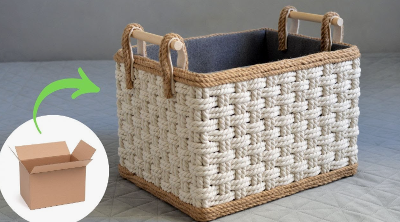 20 No-Sew DIY Crafts for Adults A sturdy rectangular storage basket made from a recycled cardboard box transformed with woven off-white and brown rope, a dark interior lining, and wooden handles, showcasing an inspiring no-sew DIY craft for adults.