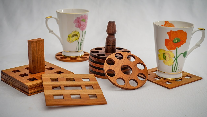 A collection of handmade wooden drink coasters with holders, displayed alongside floral mugs, presented as a project idea under the keyphrase one hour crafts.