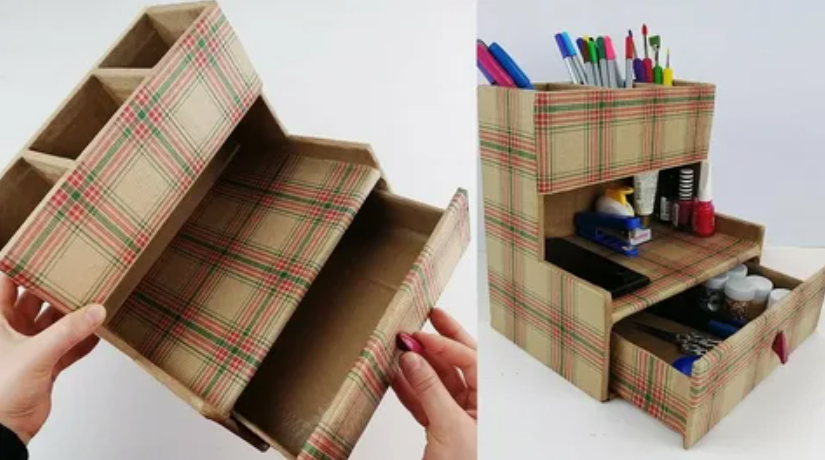 A handmade tiered desktop organizer crafted from cardboard and covered in a red, green, and beige plaid pattern, featuring pen compartments, open shelves, and a pull-out drawer, presented as a DIY craft project under the keyphrase one hour crafts.