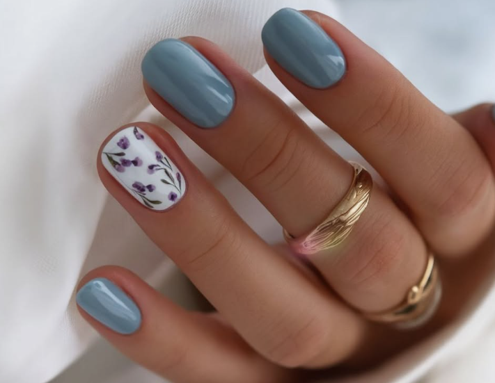 25 Short Fall Nail Ideas for 2026: Chic, Classy & Easy Designs Short fall nail ideas featuring slate blue glossy polish and a white floral accent nail.
