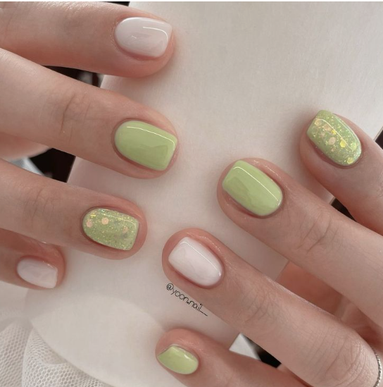 25 Short Fall Nail Ideas for 2026: Chic, Classy & Easy Designs Short fall nail ideas featuring glossy sage green and milky white solid polish with sparkly glitter accent nails.