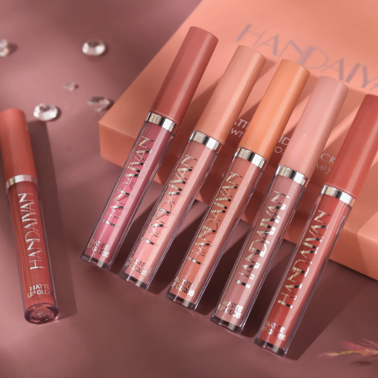 Beauty Products You Actually Need: A Minimalist Guide to Your Beauty Collection Flat lay arrangement of Handaiyan matte liquid lip gloss tubes in various nude and pink shades, displayed on a warm pink background featuring beauty products you actually need.