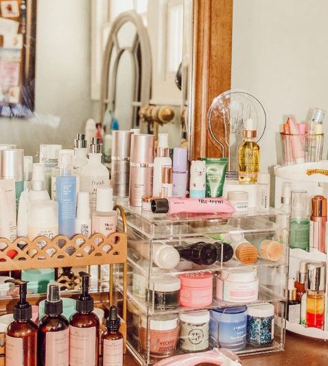 Beauty Products You Actually Need: A Minimalist Guide to Your Beauty Collection A vanity table organizer overflowing with a collection of beauty products you actually need, including skincare bottles, creams, and makeup organizers.