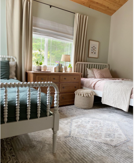 spring living room decor featuring twin spindle beds dressed in soft teal and pink bedding with a patterned area rug