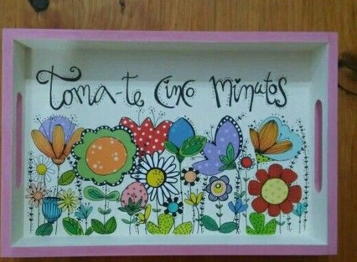 A decorative wooden serving tray featuring hand-painted colorful cartoon flowers and Portuguese text, showcasing easy crafts for people who arent artistic.