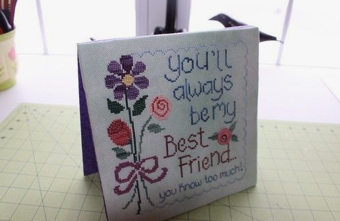 A handmade cross-stitch greeting card featuring floral embroidery and the text "You'll always be my Best Friend... you know too much!" making it a thoughtful option for crafts for people who arent artistic.