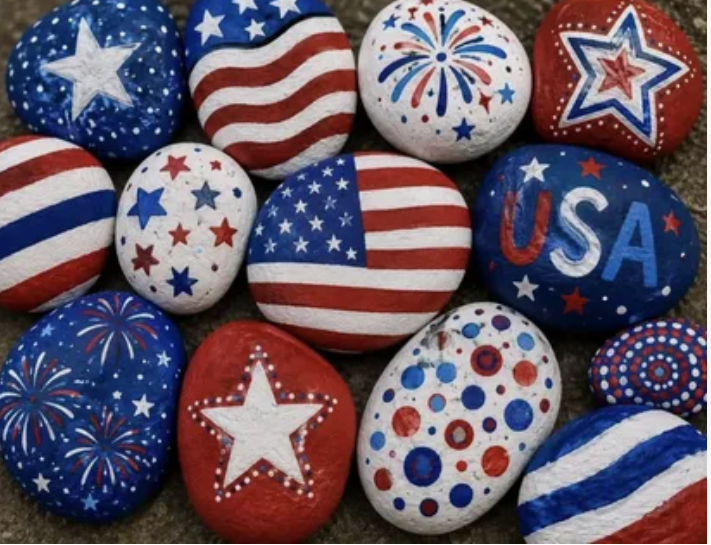 A collection of smooth garden rocks hand-painted with patriotic American flag designs, stars, and fireworks, showcasing creative home decor ideas without buying anything.