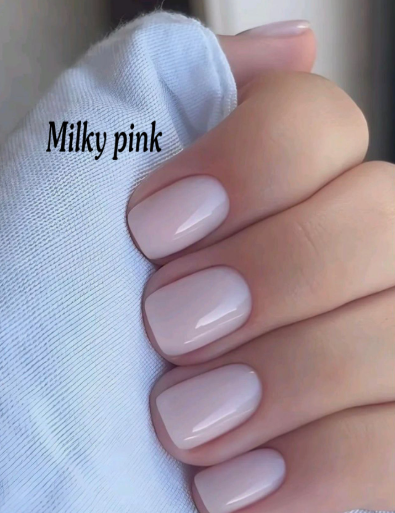 25 Nail Colors That Make Hands Look Younger A close-up of short square nails styled in a clean milky pink polish, demonstrating nail colors that make hands look younger.