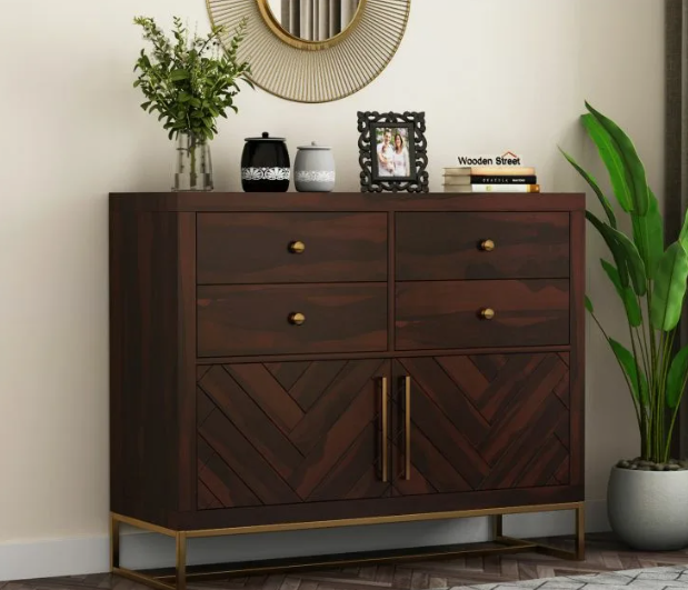 A dark wood sideboard with chevron cabinet doors and brass accents styled with a round mirror, plants, and decor items, showcasing stunning DIY crafts that look expensive for modern living room storage.