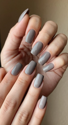 30 Classy Nail Colors for Mature Hands Hands showcasing classy nail colors for mature hands, featuring sleek, glossy taupe-gray square nails.