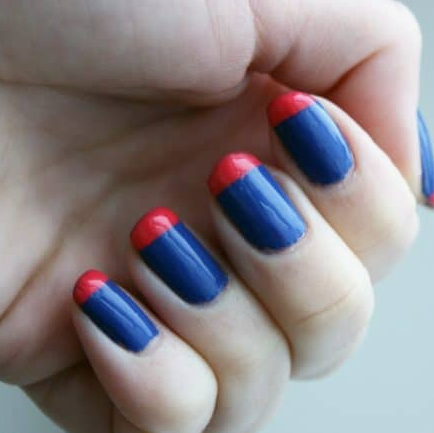 30 Classy Nail Colors for Mature Hands Hands showcasing classy nail colors for mature hands, featuring a glossy blue manicure with bold red tip accents on short square nails.