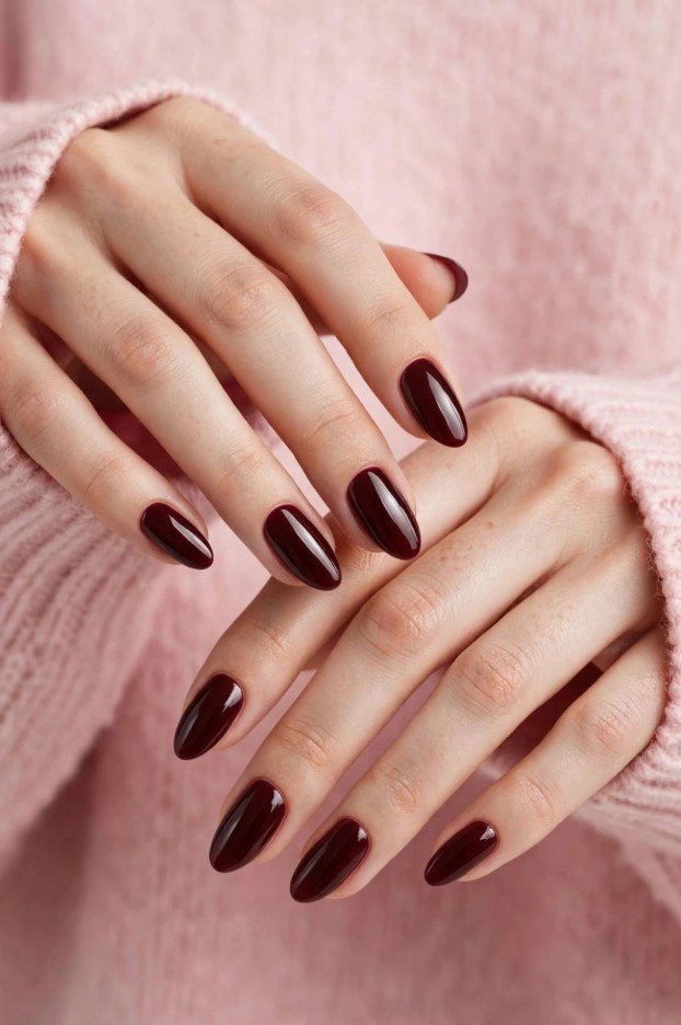 Almond-shaped fall inspiration nails painted in a glossy, rich deep burgundy and dark wine-red polish.