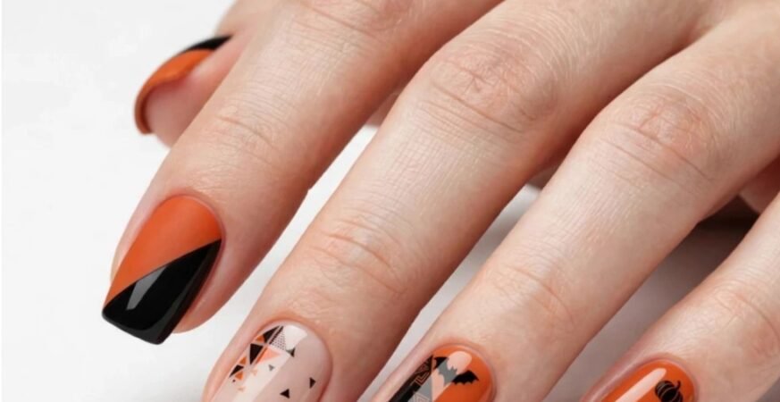 Geometric Halloween nail art with matte orange and glossy black diagonal tips, featuring mini pumpkins, bats, and triangle patterns on short coffin nails.