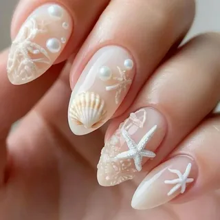 Beach-inspired almond manicure showing easy 3D nail art designs with sculpted white starfish, textured seashells, and pearl beads over a milky nude base.   