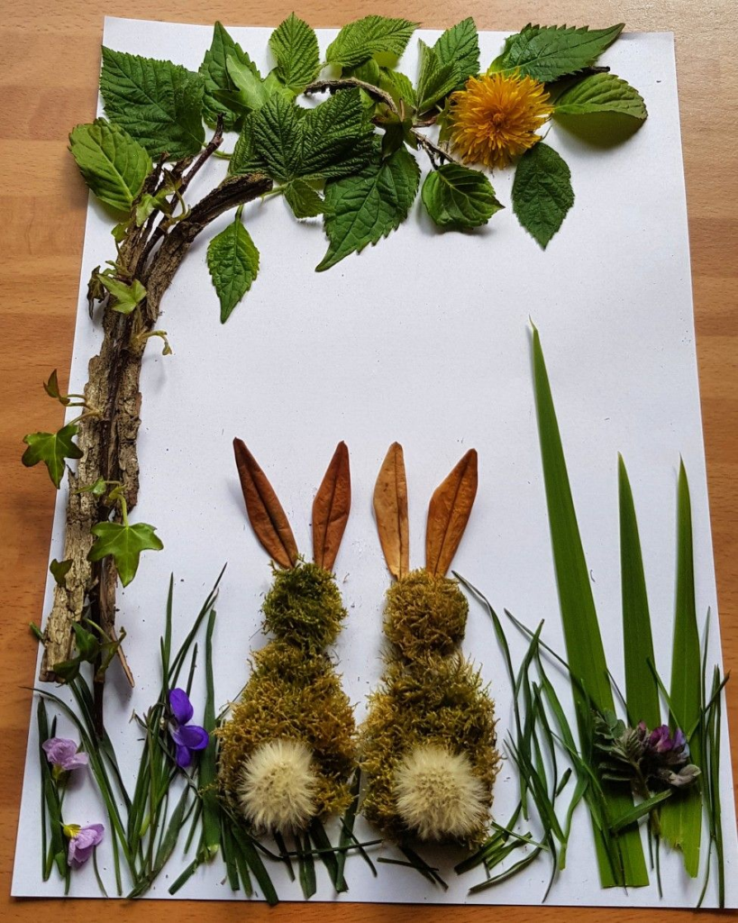 24 Preschool Seasonal Crafts for Spring, Summer, Fall & Winter A nature collage featuring two bunnies made of moss and dandelion fluff sitting under a leafy twig tree, an inspiring idea for preschool seasonal crafts.