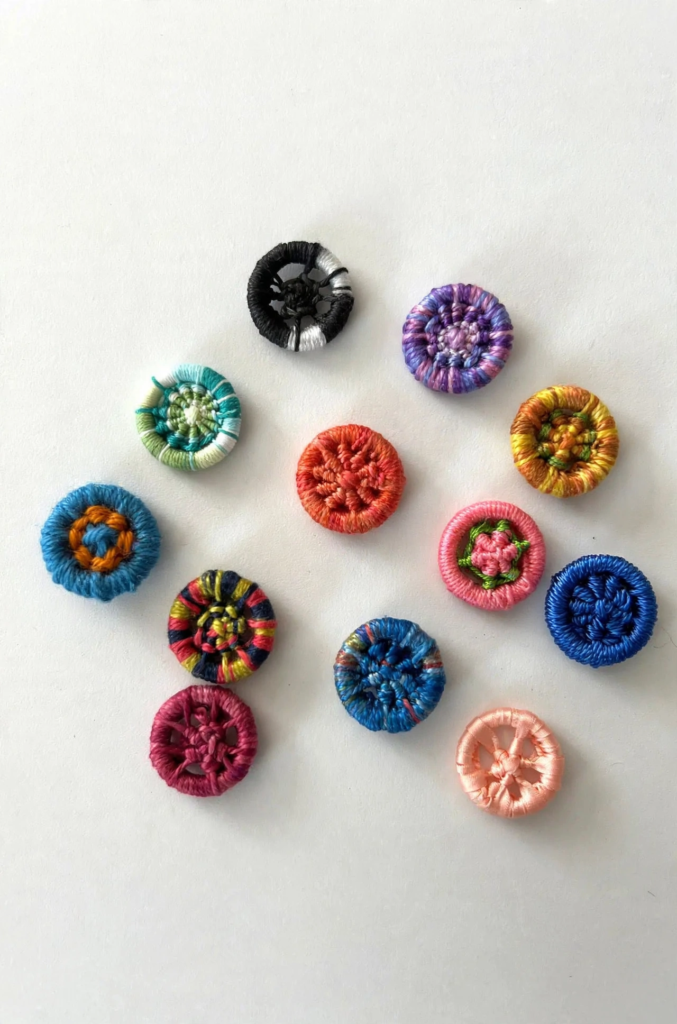 20 Nostalgic Crafts Making a Comeback in 2026 Collection of colorful handcrafted Dorset buttons woven with vibrant embroidery threads, showcasing nostalgic crafts 2026 needlecraft and button making ideas.