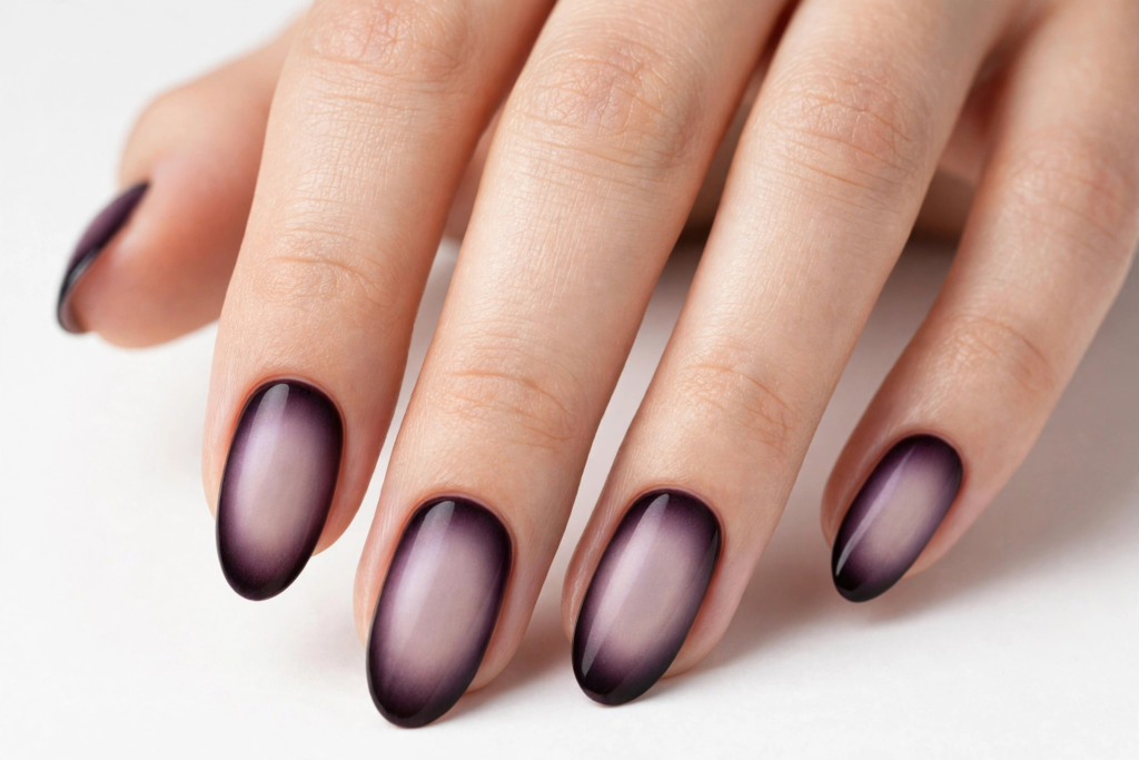Glossy oval-shaped aura nails featuring a soft nude center with dark purple airbrushed edges for fall plum nails 2026.   