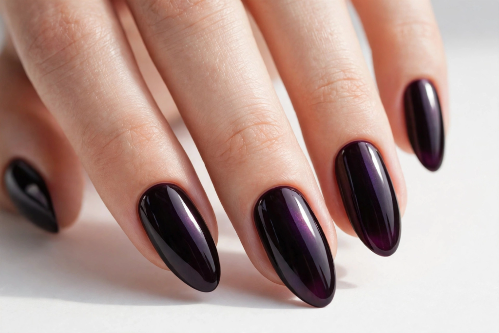 High-shine oval nails painted in a deep plum-black shade with subtle purple magnetic shimmer for fall plum nails 2026.   