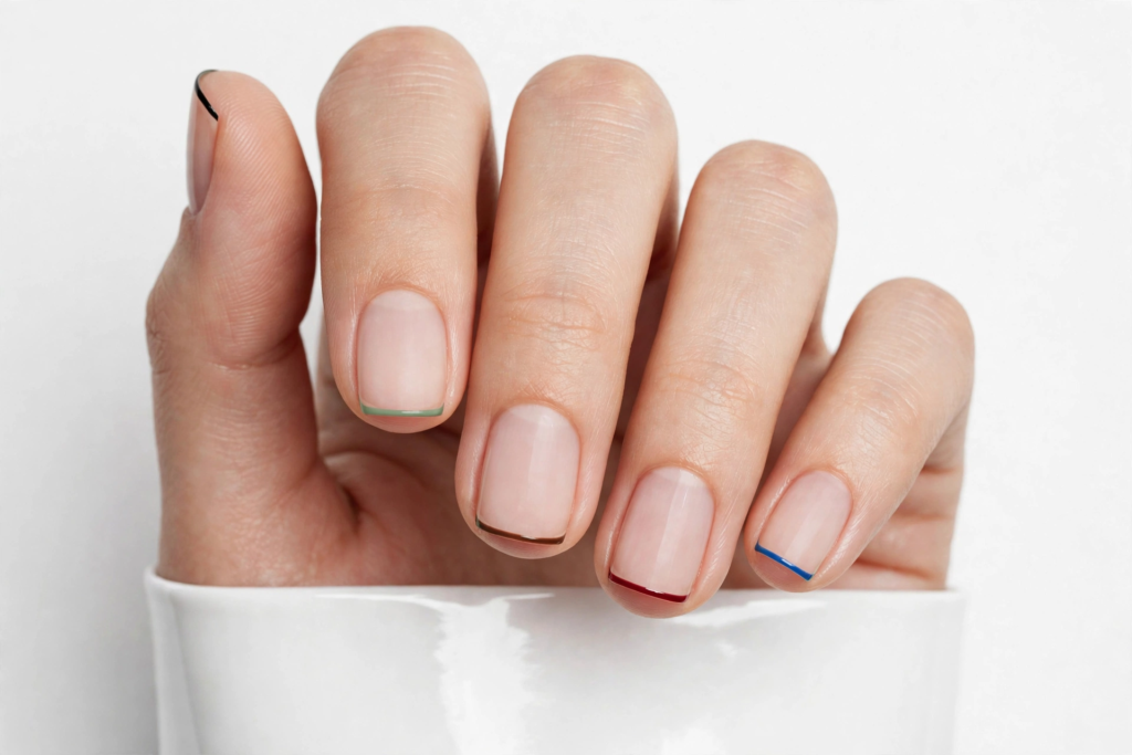 Nails Inspo 2026: 30+ Trendy Nail Ideas to Save Nails inspo 2026 showcasing a minimalist multicolored micro French tip manicure on clean, square-oval nude nails.