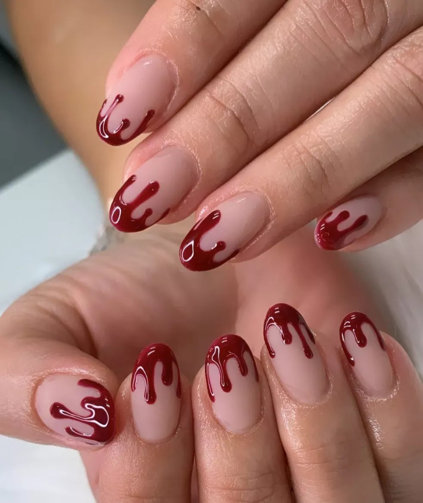 Edgy Halloween nail inspo 2026 showcasing glossy nude almond nails with 3D deep red dripping vampire blood French tips.   